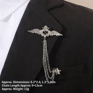 Détail d'une broche baroque argentée avec chaînes sur le revers d'un veston noir