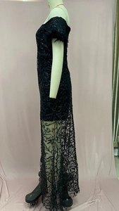 Detail eines schulterfreien schwarzen Pailletten-Abendkleids mit transparentem Saum
