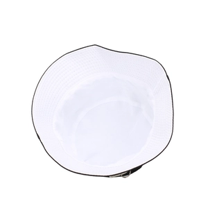 White cotton bucket hat with black trim and silver metal ring seen from a top-down view
