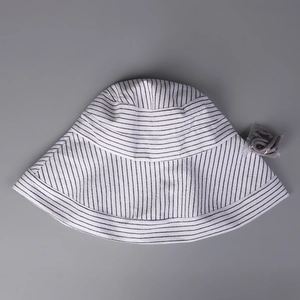 Flat lay of striped cotton linen sun hat with detachable gray adjustable chin strap