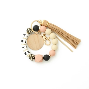 Detail of MAMA silicone bead keychain with leopard print beads and a soft brown tassel