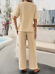 Back view of women's beige waffle knit two-piece set with short sleeves and wide-leg pants