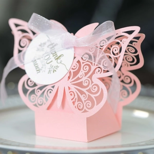 Macro view of pink butterfly hollow laser cut candy box with ribbon and thank you tag