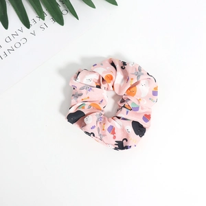 Pink fabric hair scrunchie featuring cute Halloween patterns of ghosts and bats