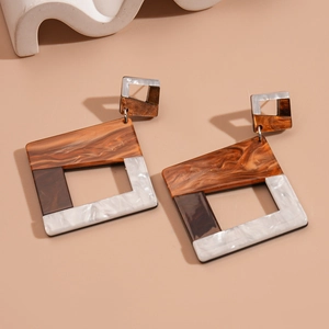 Macro shot of tortoiseshell acrylic geometric square earrings with marble texture detail