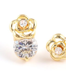 Gros plan détaillé de boucles d'oreilles roses dorées avec un grand zircon rond brillant