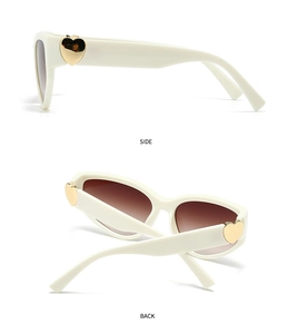 Detail of cream frame sunglasses featuring golden heart-shaped hinge and gradient lenses
