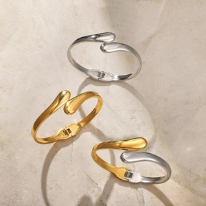 Detailed shot of polished stainless steel hinge bracelets in gold and silver finish