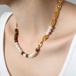 Detail of necklace with gold coffee bean links, white pearls and tiger eye stones