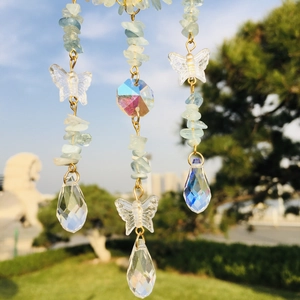 Detail of hanging crystal suncatcher with blue raw stones and butterfly prisms