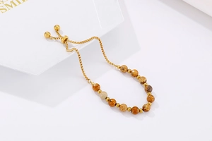 Macro detail of adjustable golden box chain bracelet with natural turquoise stone beads