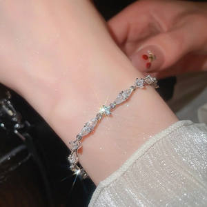 Close-up of sparkling waterdrop and square zircon silver bracelet on woman wrist