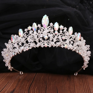 Close-up of silver Baroque crown with AB crystals and rhinestones on dark fabric