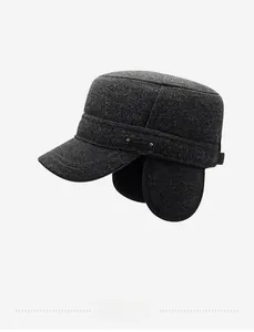 Detail of dark grey winter military cap featuring ear flaps and side metal logo