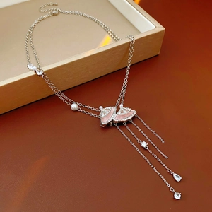 Macro view of silver fan-shaped necklace with pink resin pendant and crystal tassels
