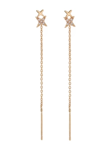 Macro shot of long gold tassel earrings with zircon-studded double cross stars