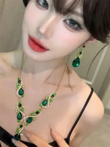 Detailed view of elegant green teardrop zircon necklace and earrings set worn by a model