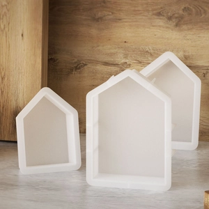 Detailed view of three house-shaped silicone molds for resin casting and DIY crafts
