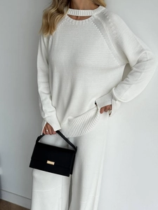 Minimalist white knit sweater set with slit neckline and high-waist straight leg pants