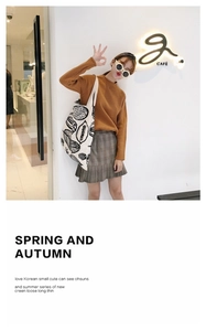 Dettaglio borsa tote in tela bianca con stampa floreale abbinata a maglione autunnale
