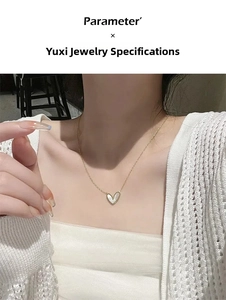 Close-up of heart-shaped white mother of pearl pendant necklace on a gold chain