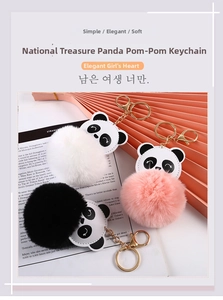 Close-up of fluffy panda pompom keychains in black, white, and pink with gold hardware