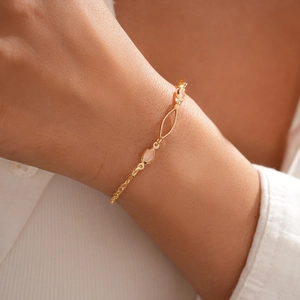 Détail du bracelet en chaîne dorée avec trois pierres ovales translucides et fermoir chic
