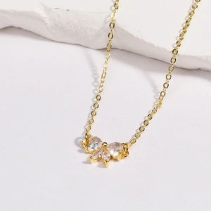Détail d'un pendentif papillon doré orné de zircons brillants pour la création de bijoux DIY