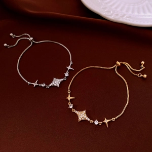 Dettaglio dei bracciali in zircone oro e argento con chiusura regolabile su seta marrone