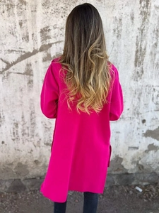 Detalle de la túnica larga oversize rojo rosa que muestra el diseño de la abertura