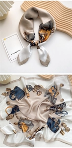 Detail of silk scarf with champagne gold chain print on an elegant wooden tray