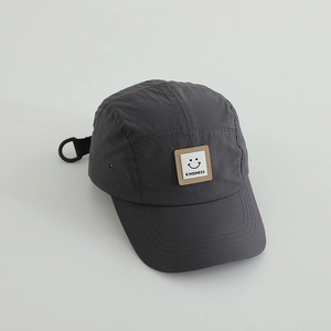 Detail of dark grey quick-dry five-panel cap with smiley patch and adjustable strap