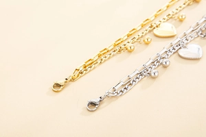 Close-up of double-layered stainless steel bracelet with heart charms in gold and silver