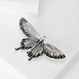 Macro shot of silver and black enamel butterfly brooch with intricate wing textures