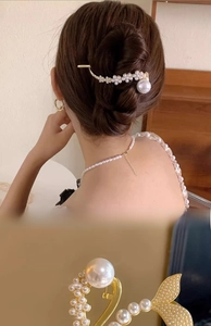 Detail of elegant pearl hair clip with golden alloy frame and clustered white imitation pearls