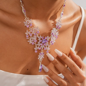 Detail view of a vintage flower necklace with purple zircon and water drop pendant on neck
