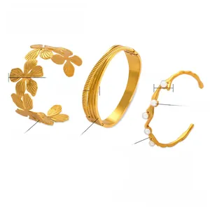 Three 18K gold-plated titanium steel bangles with floral, striped and pearl details
