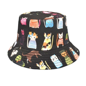 Détail des motifs de chats de dessin animé sur le tissu en toile noire du chapeau bob