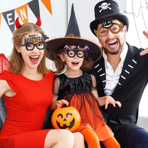 Family wearing Halloween party glasses with spider and bat designs in festive setting