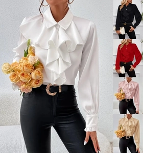 Dettaglio delle eleganti balze a jabot su una camicia di raso bianco a maniche lunghe