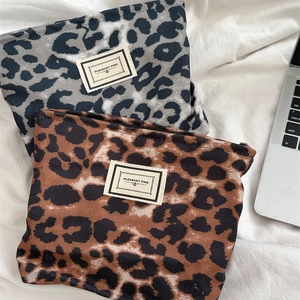 Dettaglio di pochette con stampa leopardata grigia e marrone e etichetta tessuta