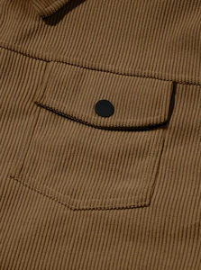 Macro shot of brown corduroy shirt pocket with a durable black snap button closure