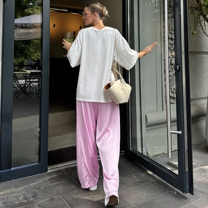 Rückansicht einer lässigen rosa Schlaghose mit hoher Taille und weißem Baumwollshirt