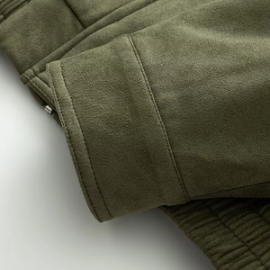 Dettaglio giacca scamosciata verde militare con trama del tessuto e cuciture rifinite