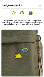 Detail of cartoon enamel taco and pot pins on a green canvas bag with sharp metallic finish