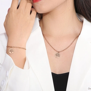 Dettaglio della collana albero della vita e del bracciale a sfere in oro rosa su modella