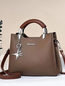 Brown litchi leather bucket bag with silver logo and star pendant on neutral background