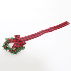 Christmas wreath with green pine needles, red berries, and buffalo plaid bow decoration