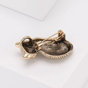 Macro view showing the bronze animal brooch back with pin mechanism and vintage texture