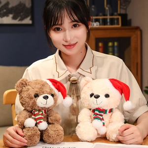 Cute Christmas teddy bear plush toy with festive hat and striped scarf held by hand